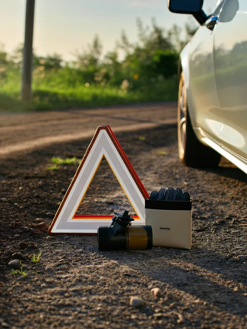 Kit de sécurité routière ouvert sur un bas-côté gravillonné près d'une voiture
